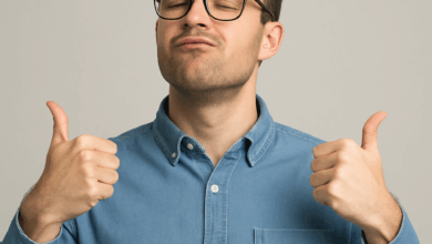 Portrait d’un homme sûr de lui, en chemise en jean et lunettes, affichant un petit sourire confiant avec les mains levées comme pour dire "je suis exceptionnel